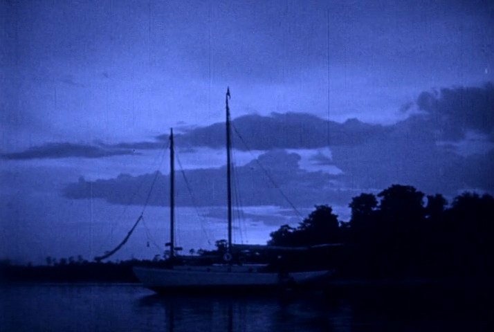 Schooner at anchor at dusk in a blue-tinted frame from Wild Oranges